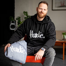 Laden Sie das Bild in den Galerie-Viewer, Portraitfoto von Chris Hillus mit neuem Design des Hoodie mit Schriftzug HOODIE. Hoodie in Schwarz und Hellgrau, Oversize und Overgemütlich